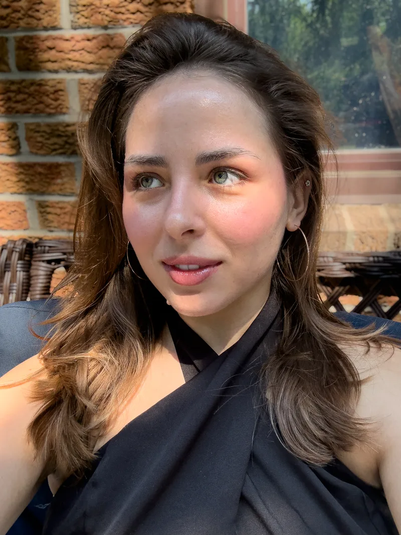Kateryna Kravtsova outdoors in a black top against a brick wall